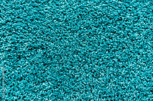 Texture of a turquoise carpet with a large nap.