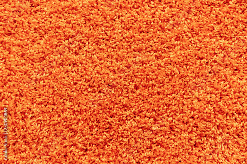 Texture of a orange carpet with a large naps.