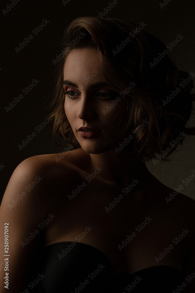 Stunning brunette model with curly hair wears lingerie posing with contrast light at studio Stunning brunette model with curly hair wears lingerie posing with contrast light at studio