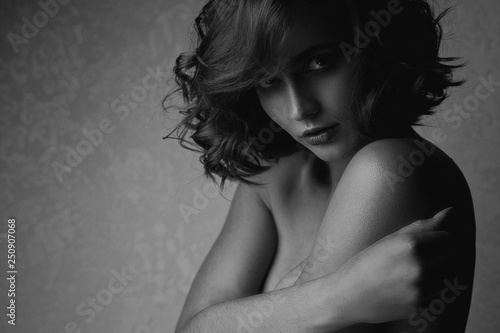 Black and white portrait of sexy brunette model with naked shoulders. Space for text