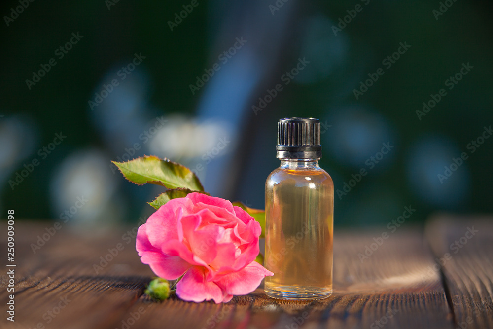 Essence of rose on table in beautiful glass bottle Essence of rose on table in beautiful glass bottle