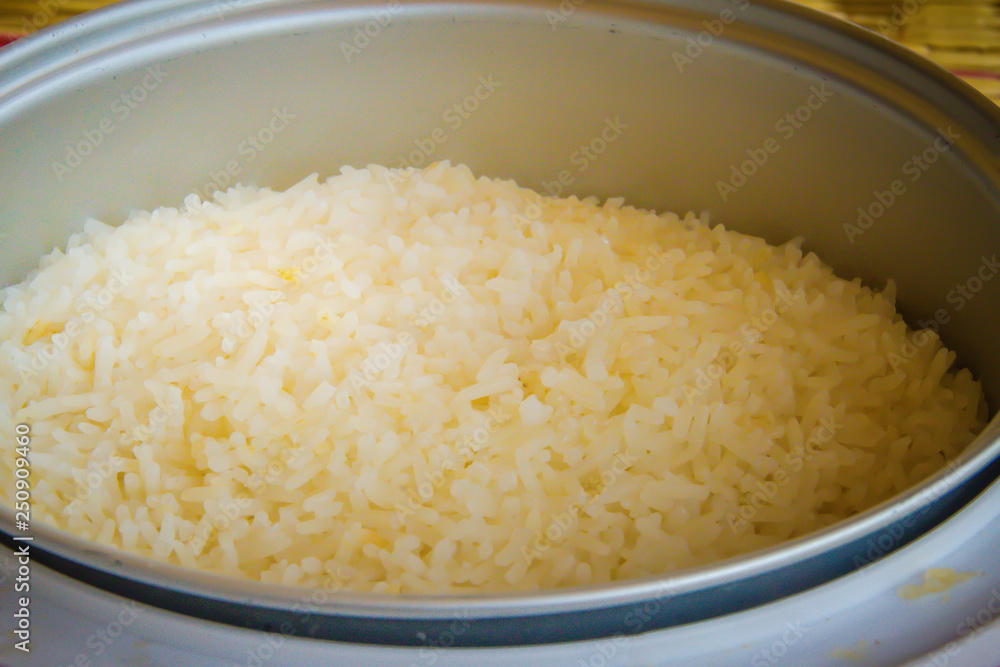 Cooked jasmine rice in the electric rice cooker pot and ready to serve and eat. Cooked jasmine rice in the electric rice cooker pot and ready to serve and eat.