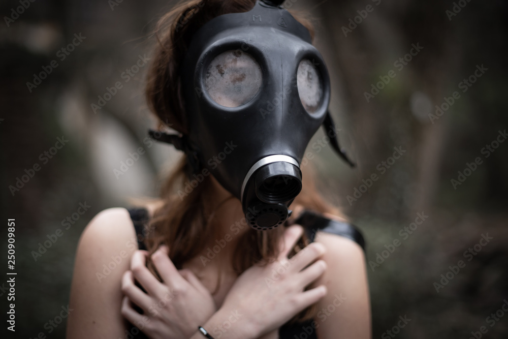 Portrait of anonymous woman in black clothes and gas mask standing in amazing spooky forest Portrait of anonymous woman in black clothes and gas mask standing in amazing spooky forest