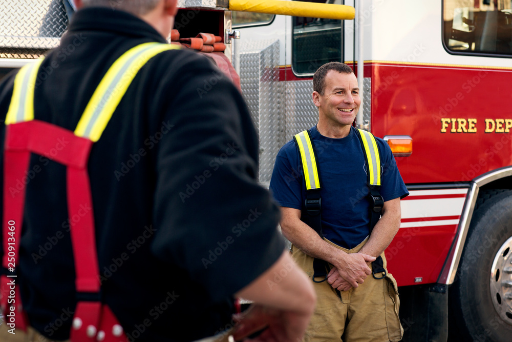 Firefighters next to fire engine Firefighters next to fire engine