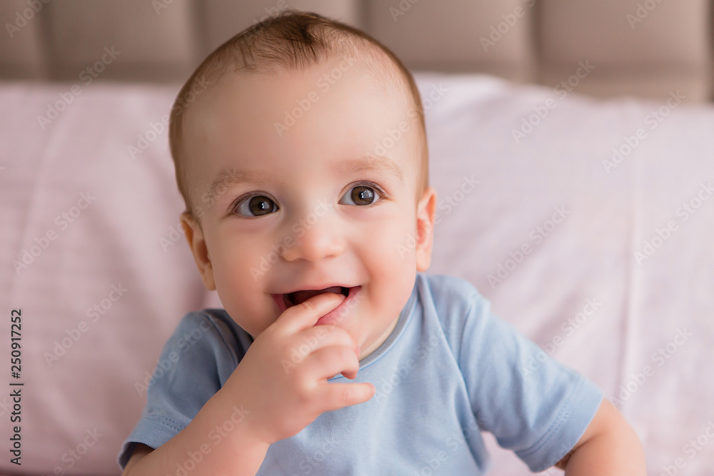 Childhood concept.baby boy in bed smiling.dorable child with beautiful blue eyes is sitting on the bed. Happy cute kid. Pillows on the bed. Childhood concept.baby boy in bed smiling.dorable child with beautiful blue eyes is sitting on the bed. Happy cute kid. Pillows on the bed.
