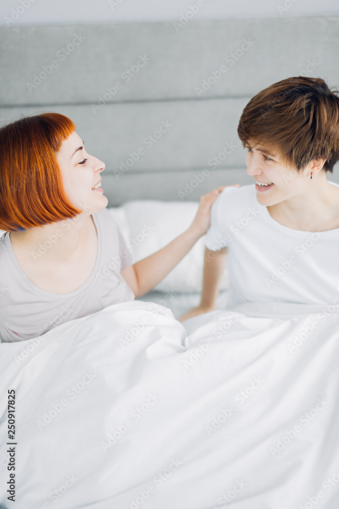 beautiful cheerful women laughing while sitting on bed. close up photo. happiness, free time beautiful cheerful women laughing while sitting on bed. close up photo. happiness, free time