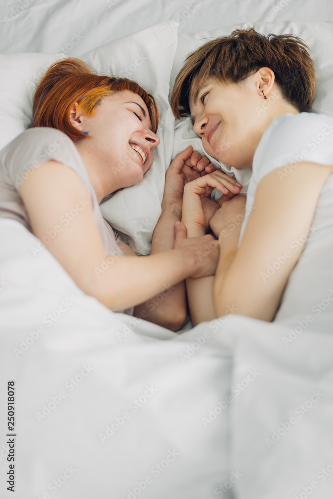 attractive girls having a conversation while lying on the bed. close up photo. attractive girls having a conversation while lying on the bed. close up photo.