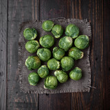 bunch of raw brussels sprouts on rustic wood with natural light