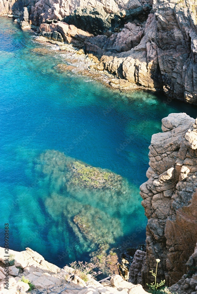 Transparent blue sea between the rocks on Spanish coat on a sunny day