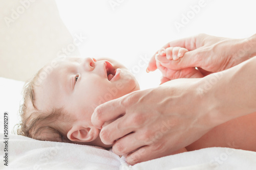 Baby and hands of a mother, indoors, blurred background
