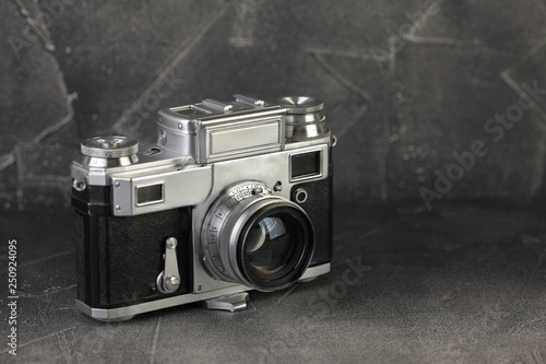 The old and rare rangefinder film camera on grey cement background.