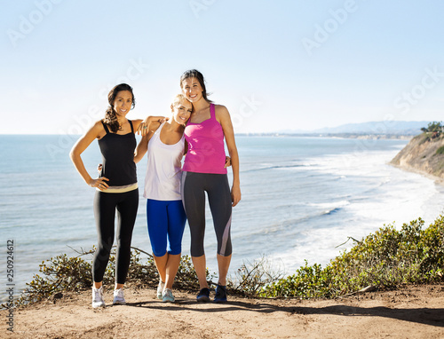 Smiling young women against sea  photo