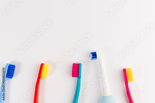Red, blue, light blue and pink toothbrushes. Taking care of teeth, dental concept. Flat lay photo, copy space, top view