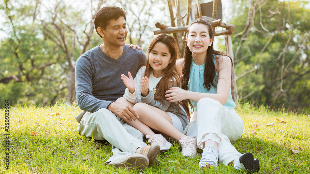 Fototapeta premium Parents and daughter happy and fun in the park