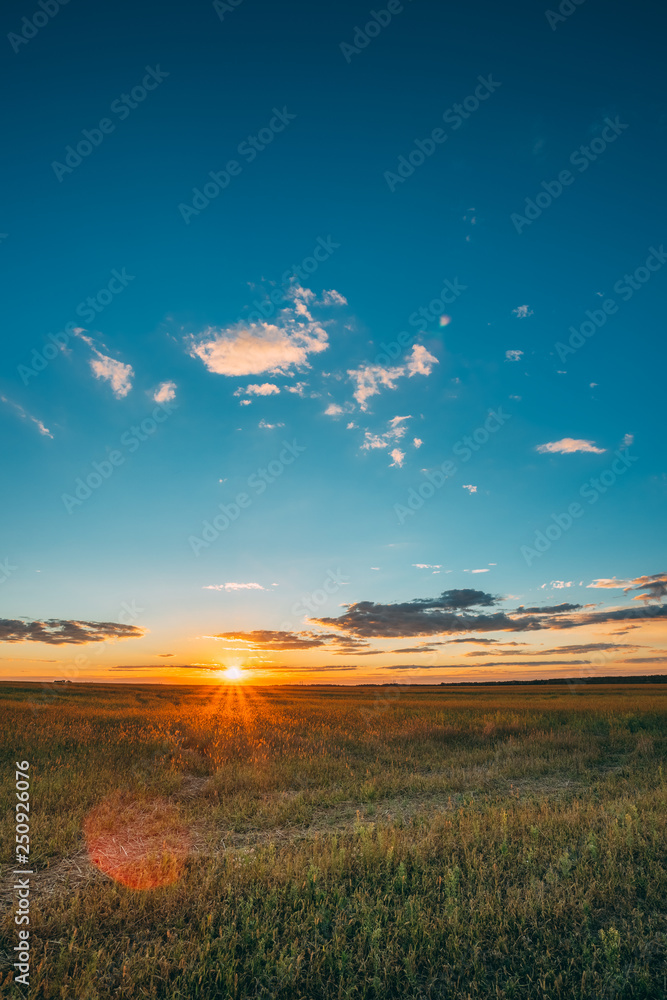 Fototapeta premium Summer Sunset Sunrise Sky Above Countryside Rural Meadow Landscape. Sun Rising Above Rural Countryside Field