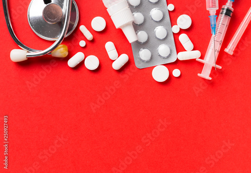 Assorted pharmaceutical medicine pills, tablets and capsules. Red background. photo