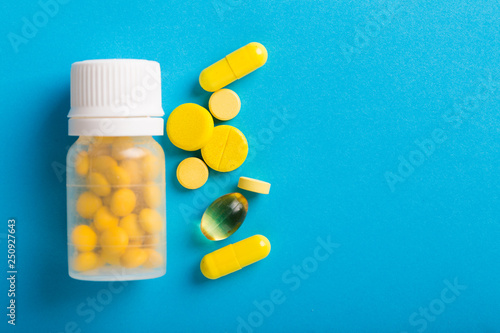 Assorted pharmaceutical medicine pills, tablets and capsules. Blue background. photo