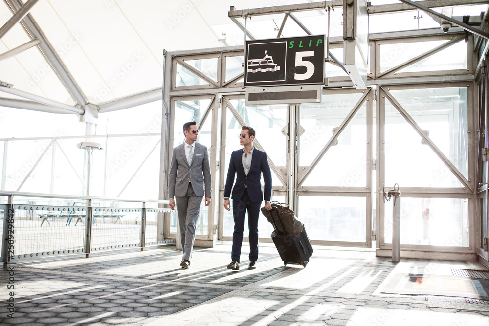 Two businessmen walking and carrying suitcase Two businessmen walking and carrying suitcase