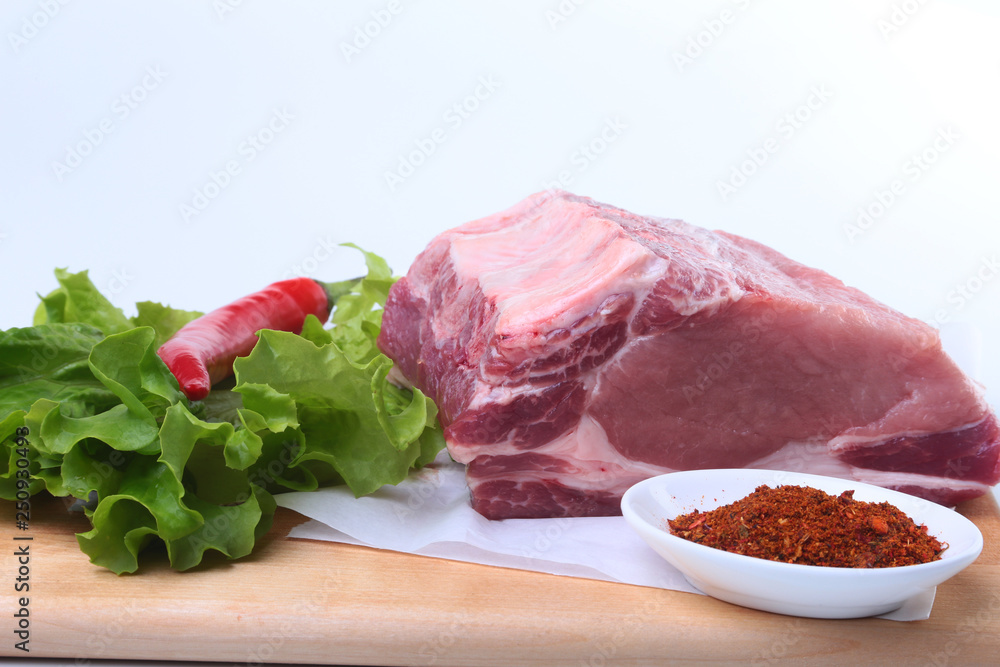 Fototapeta premium Raw pork chops with herbs and spices on cutting board. Ready for cooking.