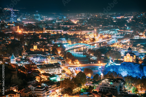 Tbilisi, Georgia. Top View Of Georgian Capital City Skyline Cityscape In Night Illuminations
