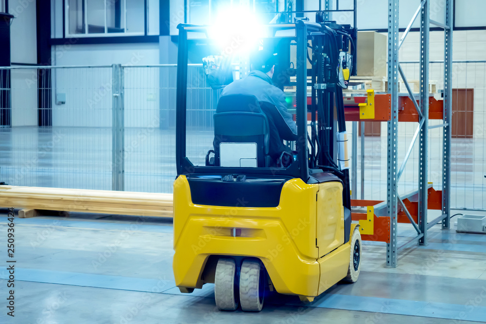 The forklift operator puts a pallet with boxes on the rack. Forklift places the goods in stock. Unloading goods. Warehousing. Warehouse storage. Logistics in stock