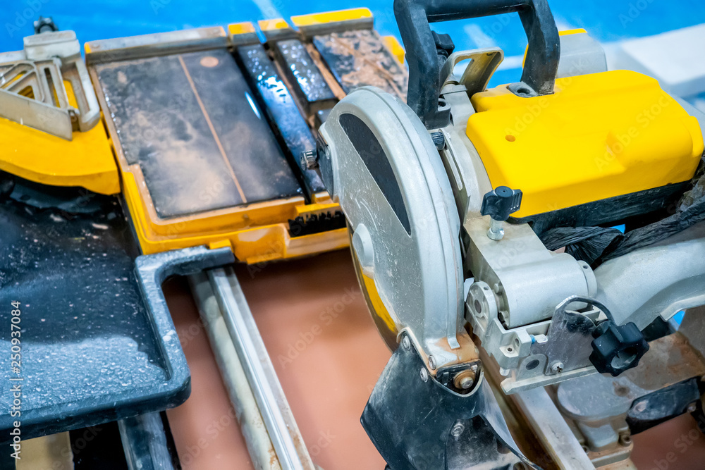 Electric tile cutter. The machine for cutting ceramic tiles and stone. Repair indoors. Tile laying equipment Electric tile cutter. The machine for cutting ceramic tiles and stone. Repair indoors. Tile laying equipment