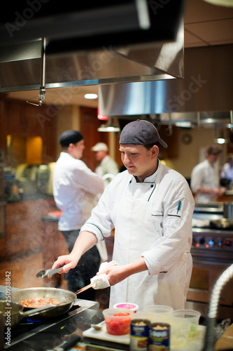 Chef cooking with saute pan in kitchen 