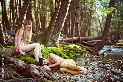 Young man and his girlfriend (16-17) relaxing by river 
