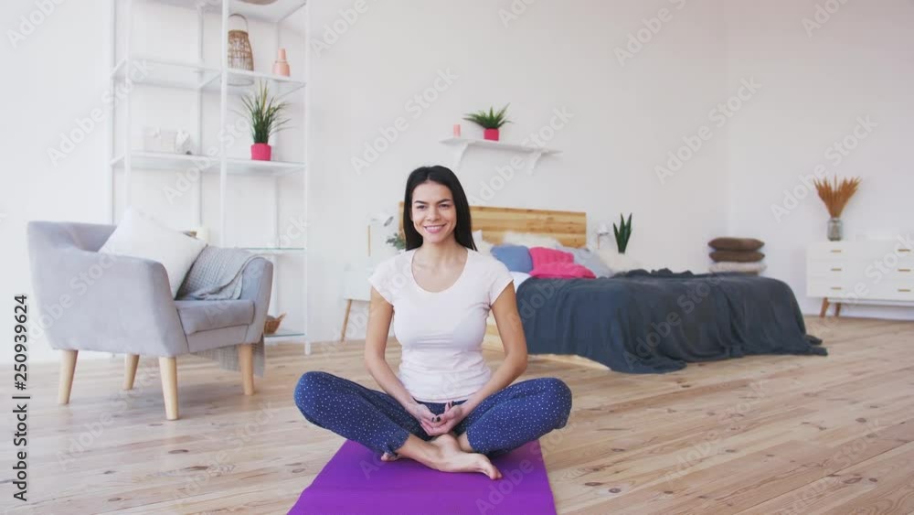 Young adult female doing yoga and smiling at home Young adult female doing yoga and smiling at home