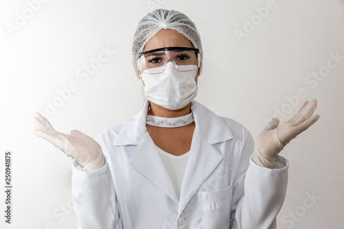 Young female doctor confused. Doctor woman confuse face expression while raising hands and shoulders. Uncertain concept on grey background