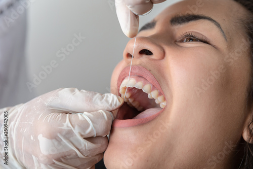 Demonstration of how to use dental wire. Dentist teaching patient how to floss.