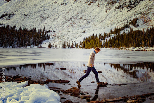 Young man walking on frozen water reservoir  photo