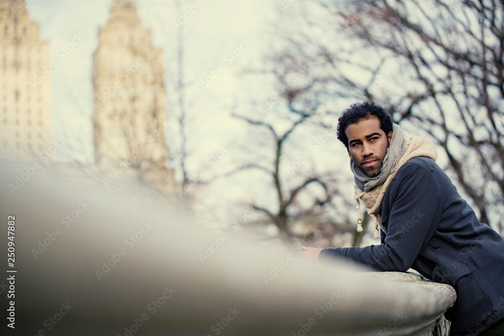 Portrait of young man leaning on railing in Central Park Portrait of young man leaning on railing in Central Park