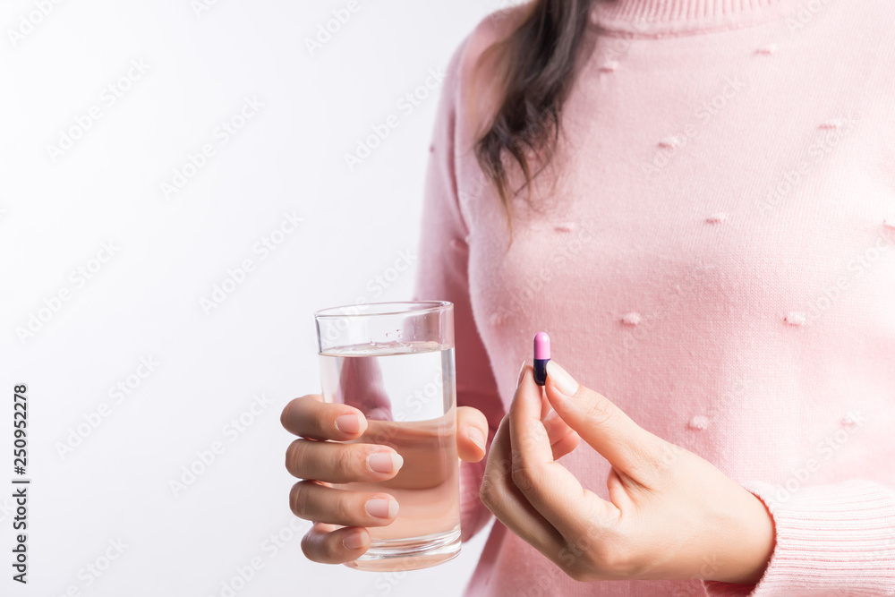 medicine, health care and people concept - close up of woman taking in pill and another hand holding a glass of clean mineral water. medicine, health care and people concept - close up of woman taking in pill and another hand holding a glass of clean mineral water.