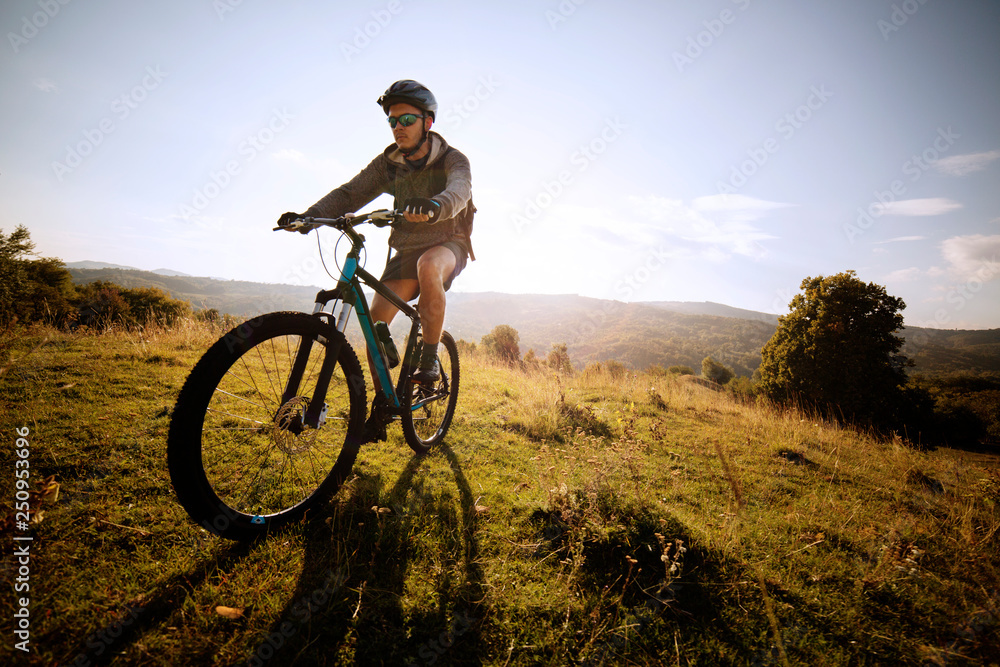 Biker with safety helmet in fields hills in background Biker with safety helmet in fields hills in background
