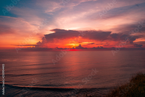 amazing scarlet sunset wuth a big clouds on beautiful tropical Bali beach