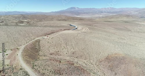 Aerial drone scene of train ridding at desertic mountainous landscape. Train of the clouds, tren de las nubes, San Antonio de los Cobres, Salta, Argentina. Touristic and recreational ride.