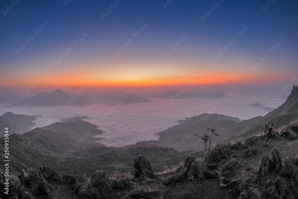 sunrise at Doi Pha Tang, beautiful mountain view morning panorama 180 degree of top hill around with sea of mist with yellow sun light and cloudy sky background, Chiang Rai, Thailand.