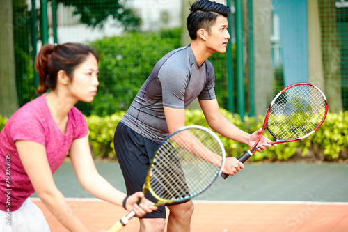 asian man and woman tennis player in mixed double match photo