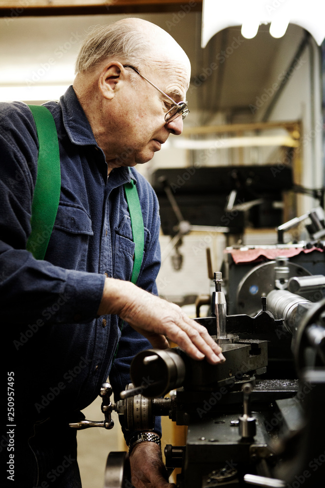 Senior man working on machine Senior man working on machine