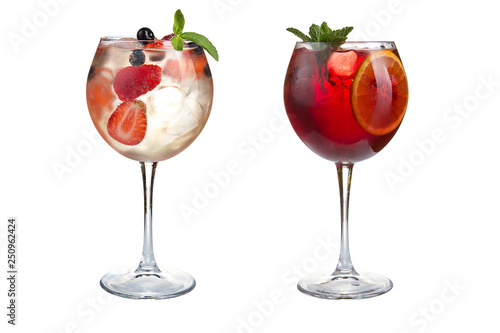 Two summer alcoholic or non-alcoholic cocktails with mint, fruits and berries on a white background. Cocktails in glass goblets.