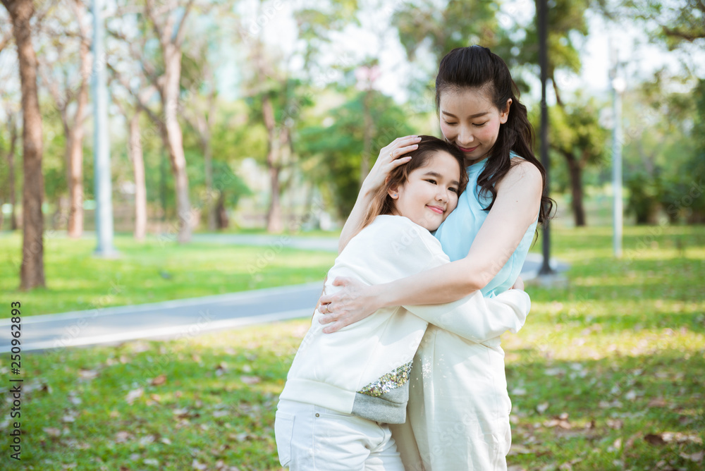 Beautiful mother hug little daughter in the park Beautiful mother hug little daughter in the park