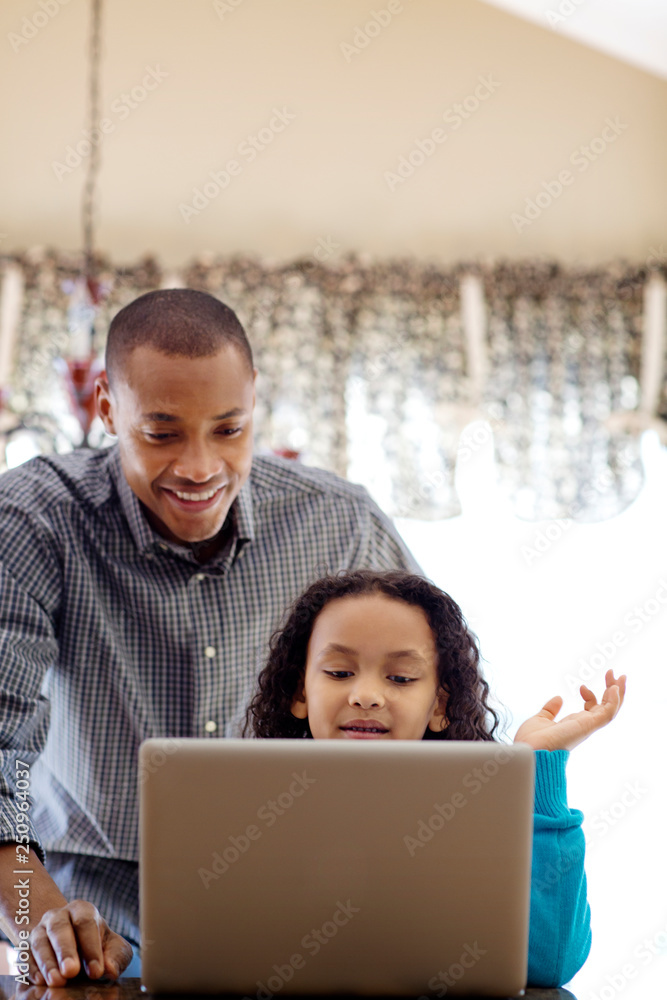 Father and daughter (6-7) using laptop at home Father and daughter (6-7) using laptop at home