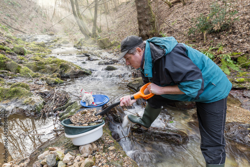Принти на полотні Adventures on river. Gold prospector is filling a sieve with sand
