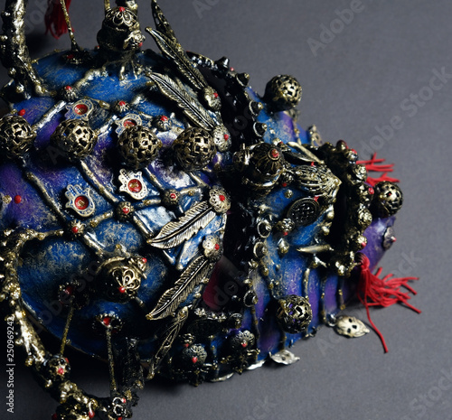 Iron demon mask with precious stones on dark background