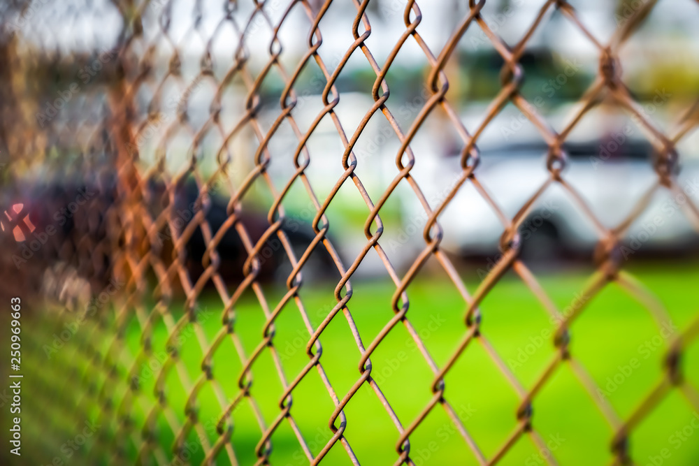 Fototapeta premium Rust steel net with blur football field.