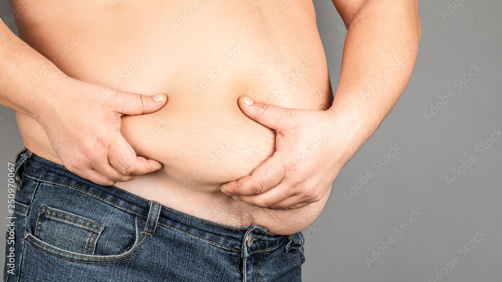 Fototapeta premium fat man, checking his weight, on a gray background