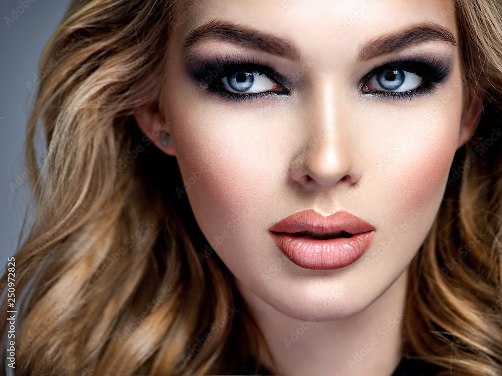 Closeup face of a beautiful girl with makeup in style smoky eyes. Closeup face of a beautiful girl with makeup in style smoky eyes.