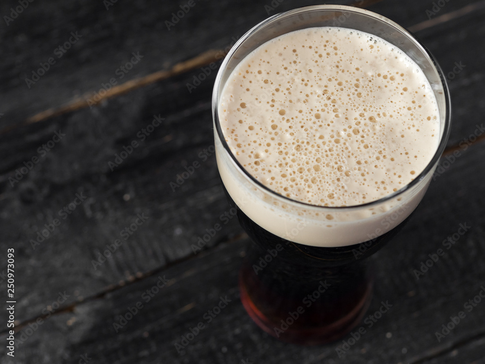 Pint of dark stout beer on wooden background Pint of dark stout beer on wooden background