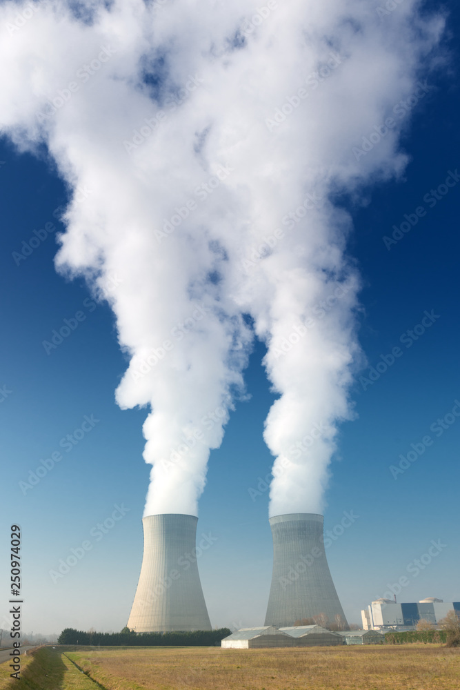 power plant cooling towers steaming on dark blue sky background power plant cooling towers steaming on dark blue sky background
